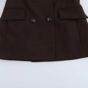 Détail d'un blazer marron foncé avec doubles boutons en résine et poches à rabat symétriques
