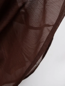 Macro shot of dark brown chiffon skirt fabric showing fine texture and neat stitching