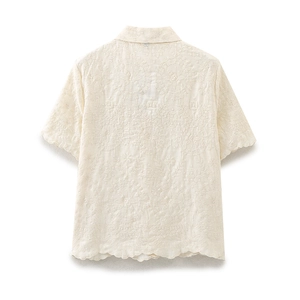 Detailed back view of cream cotton blouse with floral embroidery and scalloped edges
