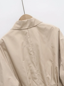 Detail view of back stitching and smooth fabric on a beige lightweight lapel jacket