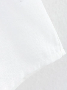 Detailed macro shot of white cotton linen shirt fabric texture and neat stitching