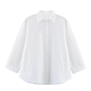 Detail view of refined eyelet embroidery and single-breasted buttons on white cotton shirt