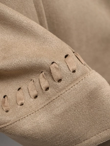 Macro shot of camel suede jacket featuring intricate woven lacing and double-needle stitching