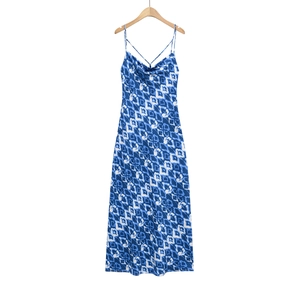 Détail d'une robe longue à imprimé géométrique bleu et blanc avec décolleté drapé élégant