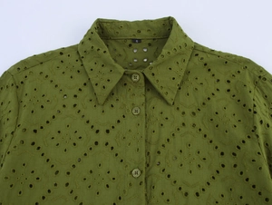 Detail of olive green shirt featuring eyelet embroidery and matching small buttons