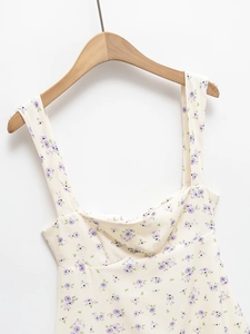 Robe d'été à fleurs violettes et décolleté carré suspendue sur un cintre en bois chic