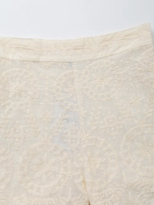 Detail shot of the cream cotton linen shorts featuring intricate floral embroidery
