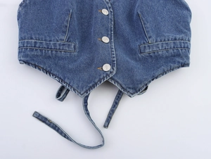 Detailed macro view of dark blue denim vest with metal buttons and lace-up hem detail