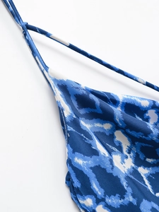 Détail de l'encolure en V et de la bretelle sur une robe à imprimé bleu et blanc