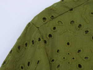 Detail of olive green eyelet shirt showing floral embroidery and delicate shoulder seam