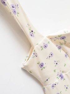 Gros plan sur l'imprimé floral violet sur coton crème avec couture de la bandoulière