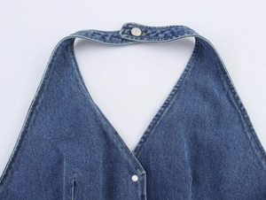Detailed view of dark blue denim halter top with silver buttons and precision stitching