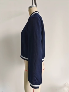 Side view of dark blue workwear jacket with white striped ribbed cuffs and collar