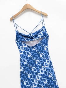 Détail de robe longue à imprimé bleu avec dos nu croisé et texture en tissu satiné