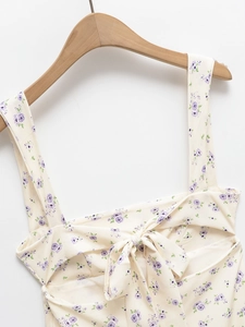 Détail d'une robe à fleurs avec nœud au dos et imprimé floral violet délicat