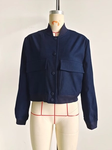 Detailed view of dark blue cropped utility jacket with ribbed collar and flap pockets
