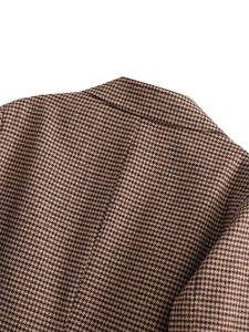 Nahaufnahme der Hahnentritt-Wollblazer-Textur mit Fokus auf Schneiderkunst und Qualität