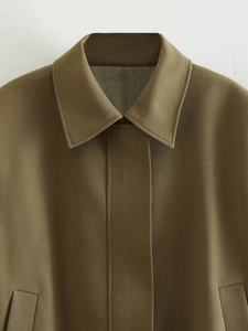 Macro detail of dark khaki workwear jacket with classic lapel and hidden placket