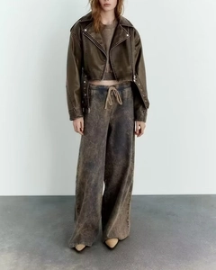 Women's vintage brown faux leather jacket styled with acid wash wide-leg denim jeans