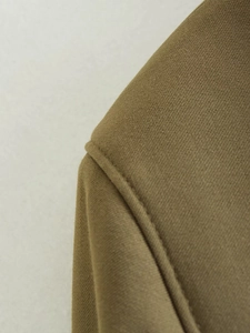 Macro view of olive brown twill fabric with precision stitching on a utility jacket