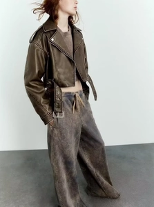 Detail showing the vintage washed PU leather texture and zip closure of a cropped jacket