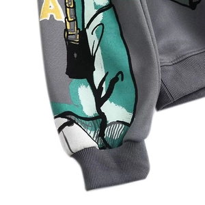 Close-up of rib-knit cuffs and yellow letter A graffiti on dark gray fleece sweatshirt