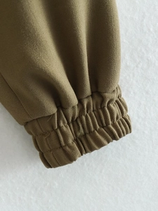 Close-up of elastic ribbed cuffs on a khaki utility jacket showing twill texture