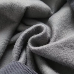 Macro view of warm fleece lining and ribbed hem on gray Y2K oversized sweatshirt