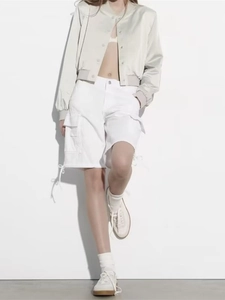 Detail of beige bomber jacket and white cargo shorts with large patch pockets