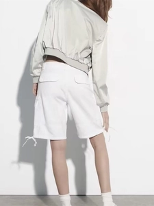 Detail view of white utility cargo shorts with drawstring hem and back flap pockets