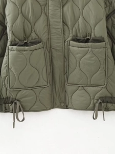 Detail of olive green quilted jacket showing water-drop pattern and functional drawstrings