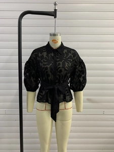 Modische schwarze Spitzenbluse mit Puffärmeln, Jacquard-Muster und Taillengürtel