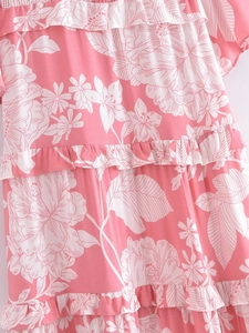 Close-up of pink floral print dress with tiered ruffle layers and soft fabric texture