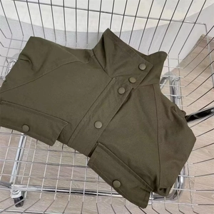 Detail of army green utility jacket showing stand collar and snap button closure