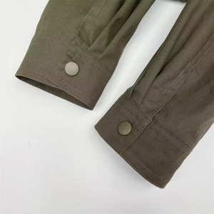 Detailed macro view of military green cotton canvas cuffs with matte metal buttons
