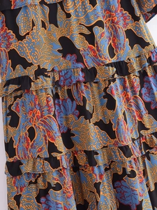 Macro shot of tiered ruffled hem on a lightweight floral rayon dress with colorful prints