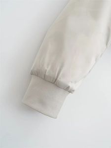 Close-up of elastic ribbed cuffs on a beige Y2K style loose-fit bomber jacket