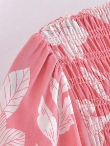 Close-up of pink floral dress featuring elastic smocked bodice and puff sleeve detail