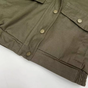 Detail of army green jacket with metal snap buttons and high-quality fabric texture