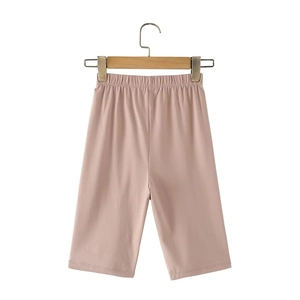 Detail of dusty pink biker shorts with elastic waistband on a wooden hanger