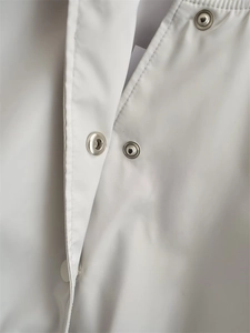 Close-up detail of silver metal snap buttons on a white Y2K style casual bomber jacket