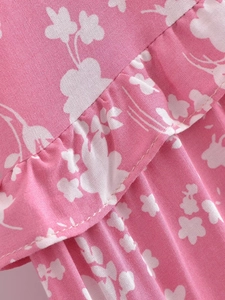 Vue détaillée du tissu floral léger avec des plis à volants délicats et imprimé rose