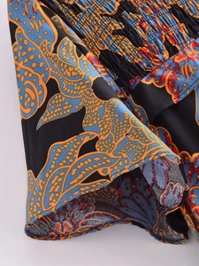 Detailed macro view of tropical floral print fabric and smocked elastic stitching on dress