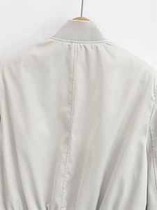 Detail of grey Y2K bomber jacket featuring ribbed collar and smooth technical fabric