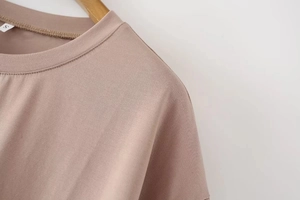 Close-up of crew neckline and stitching details on a dusty pink Y2K style slim t-shirt