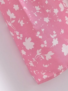 Gros plan sur le tissu en viscose rose avec imprimé floral blanc et coutures de précision
