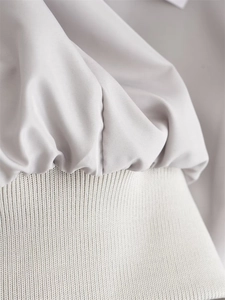 Detailed macro view of light grey woven fabric and cream ribbed knit cuffs stitching