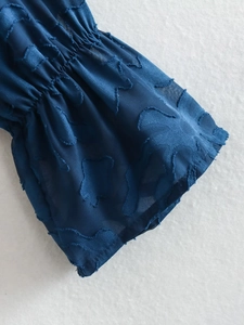 Detail of smocking cuff with jacquard pattern on a dark blue long sleeve shirt