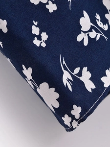 Détail macro montrant les imprimés floraux blancs sur tissu bleu foncé et coutures soignées