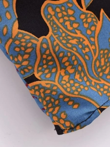 Close-up of rayon floral batik fabric with blue and orange geometric patterns